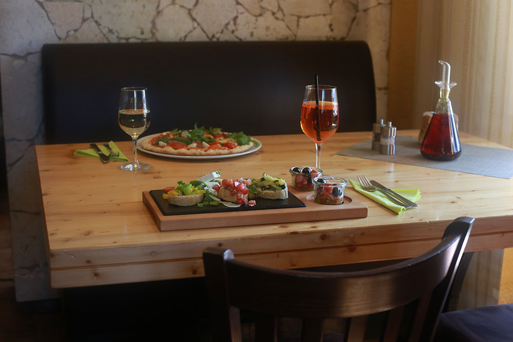 Pizza und Aperitif am Tisch